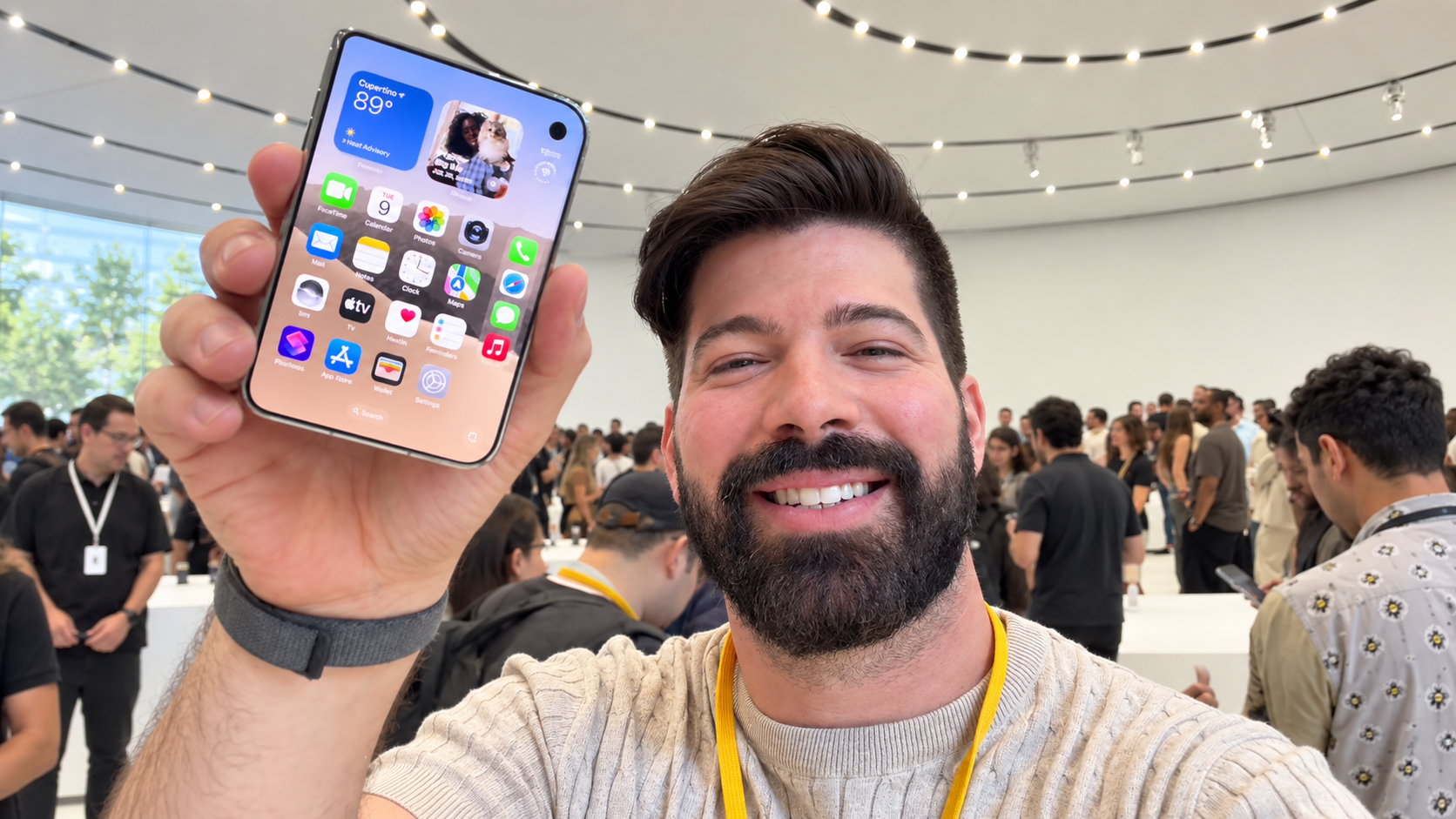 Mau Lozano mostrando un nuevo iPhone durante la cobertura de lanzamiento en Apple Park