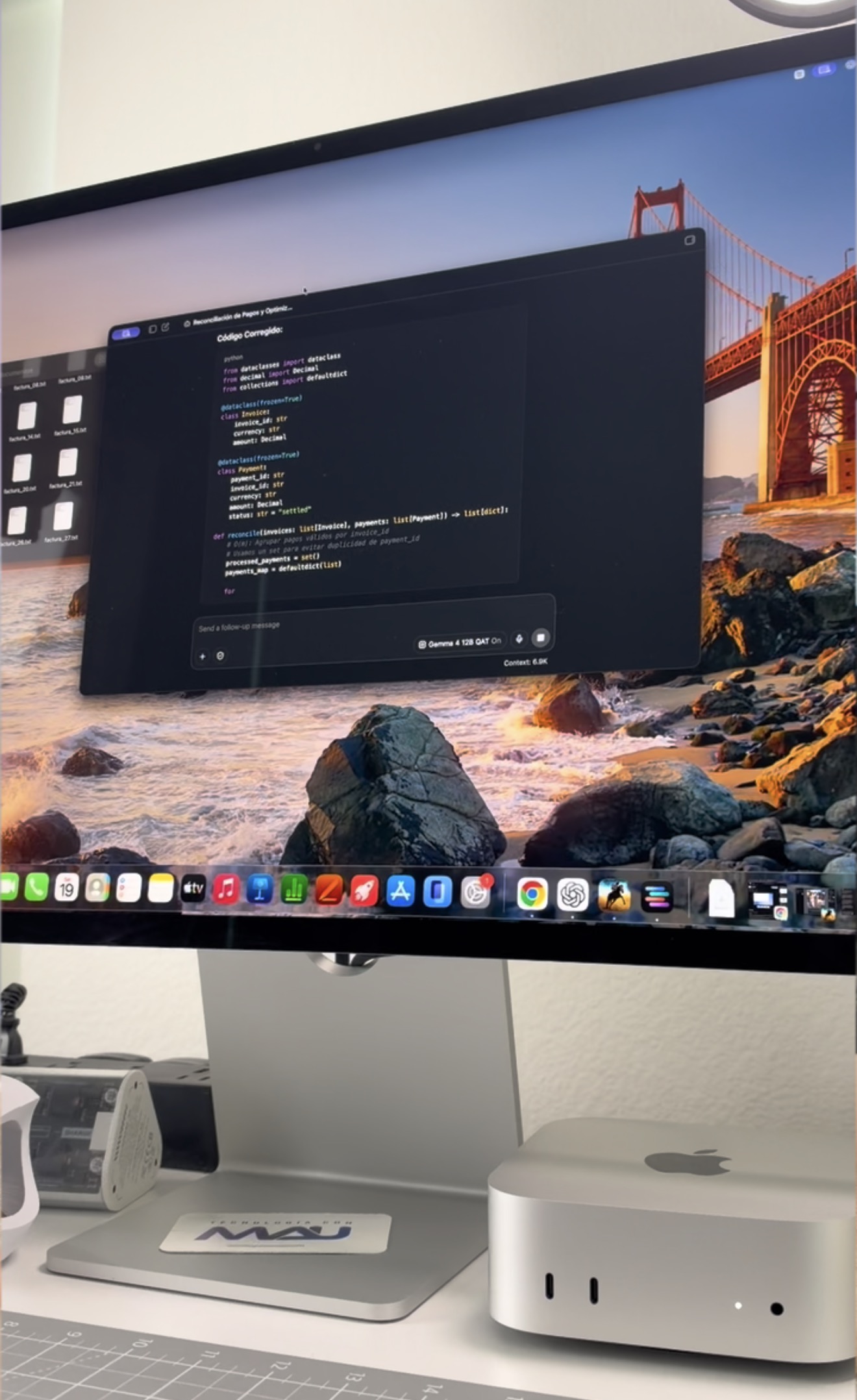 Mac mini junto a un monitor con código generado durante una demostración de IA