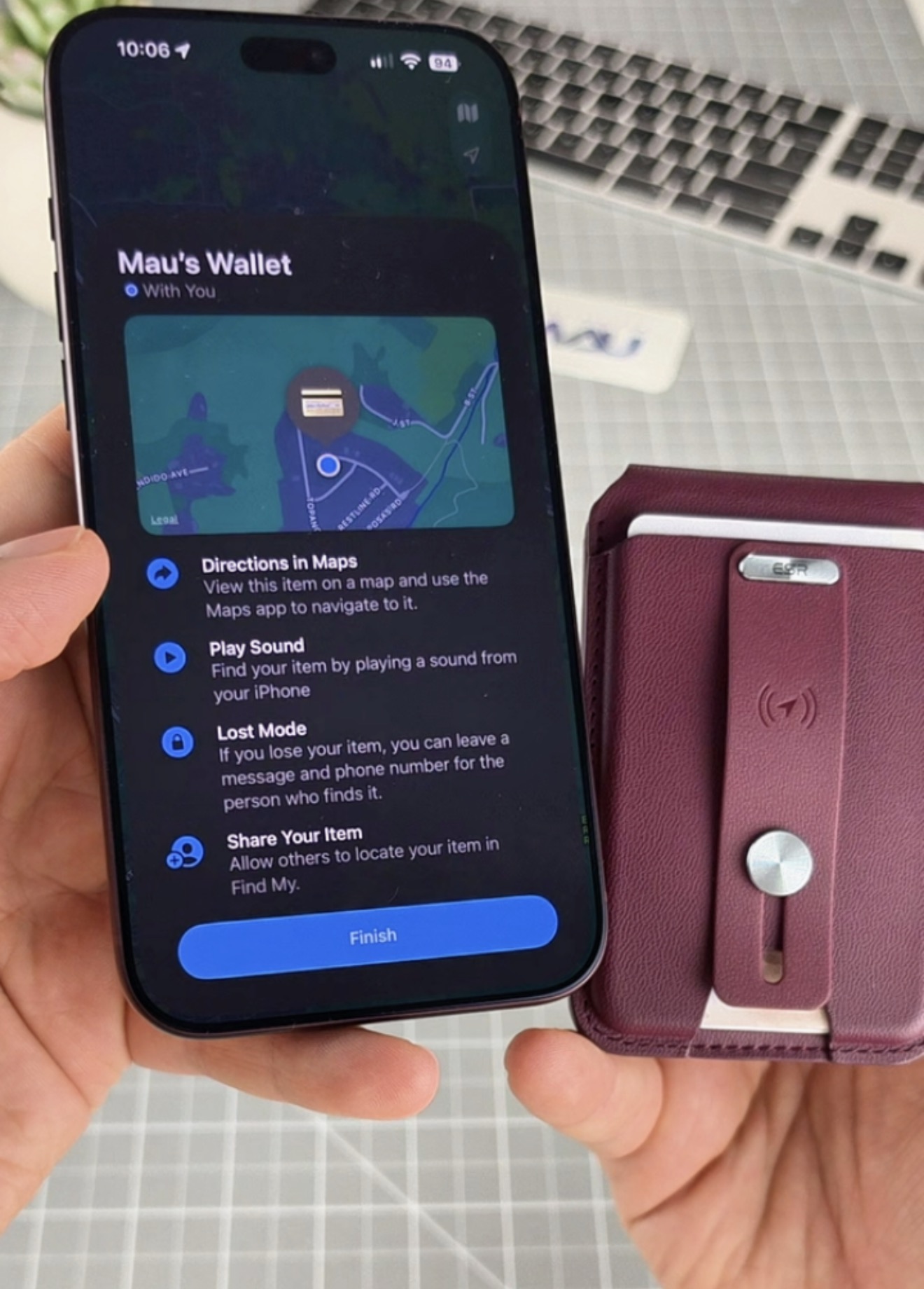 ESR Geo Wallet junto a un iPhone mostrando ubicación, indicaciones y reproducción de sonido en Find My