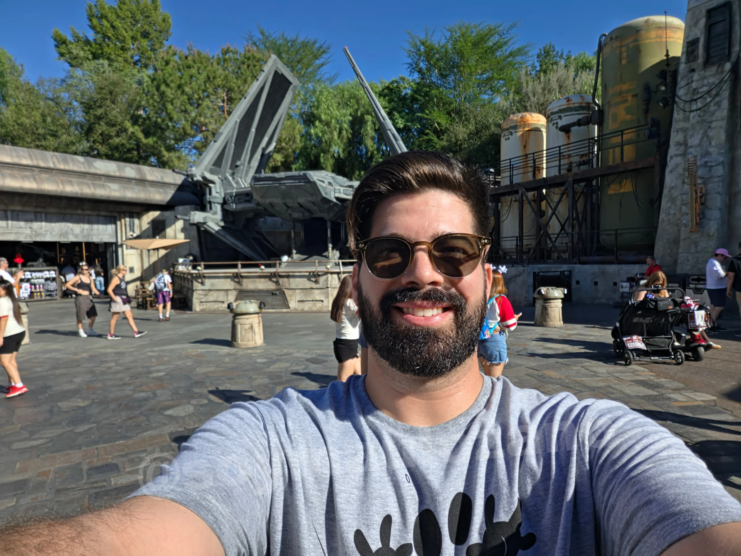 Selfie diurna de Mau con la nave y los árboles al fondo tomada con Galaxy Z Fold 8.