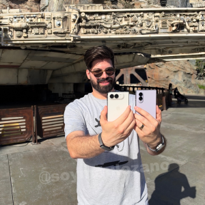 Mau sostiene un iPhone Duo y un Galaxy Z Fold 8 frente a la nave de Star Wars en Disneyland.